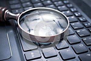 Vintage Loupe On A Black Computer Keyboard - Search Engine Optimization Concept