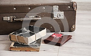 Vintage luggage with blank space of photo frame and stack old books on wooden table. Journey memory concept