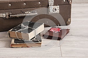 Vintage luggage with blank space of photo frame and stack old books on wooden table. Journey memory concept