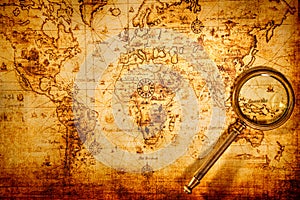 Vintage magnifying glass lies on an ancient world map