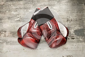 Vintage maroon leather boxing gloves on a grunge background