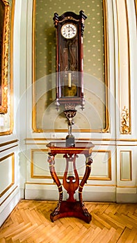Vintage mechanical wall clock with a pendulum hang on the wall. rare wooden clock in the interior
