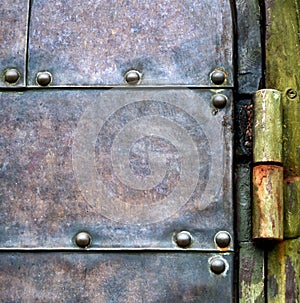 Vintage metal door with rusty hinge.