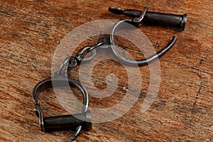 Vintage metal handcuffs on the wooden table