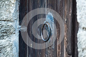 Vintage metal iron door handle on an old door made of natural wood. Horizontal orientation, selective focus. Doorknocker