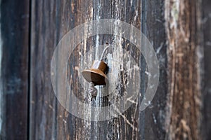 Vintage metal iron door handle on an old door made of natural wood. Horizontal orientation, selective focus. Doorknocker