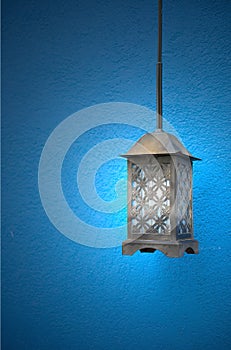 Vintage metal lamp on blue background. Streetlight beside the wall. Exterior decoration