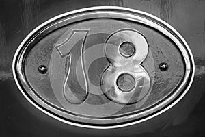 Vintage metal plate with number eighteen, detail of an old metal plate