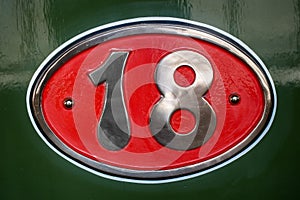 Vintage metal plate with number eighteen, detail of an old metal plate