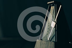 Vintage metronome, on a dark background.