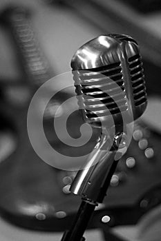 Vintage Microphone with Electric Guitar in Background, Black and White photo