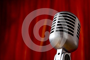 Vintage Microphone in front of red Curtain