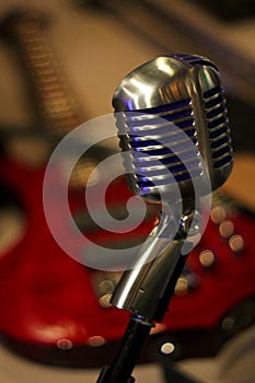 Vintage Microphone with Red Electric Guitar in Background photo