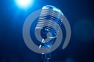 Vintage microphone standing in blue light on stage