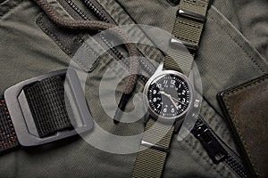 Vintage military watch and leather wallet on army green background, Classic timepiece mechanical wristwatch, Men fashion