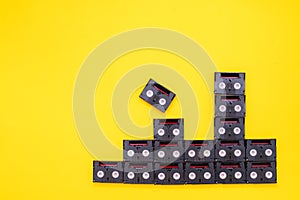 Vintage mini DV cassette tapes used for filming back in a day. Pattern made of plastic video tapes on yellow background
