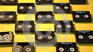 Vintage mini DV cassette tapes used for filming back in a day. Pattern made of plastic video tapes on yellow background