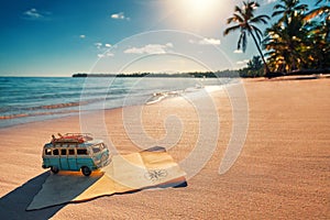 Vintage miniature van and old treasure map on the tropical beach