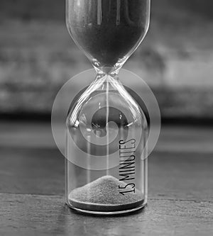 Vintage 15 minutes sandglass or hourglass in black and white style photo