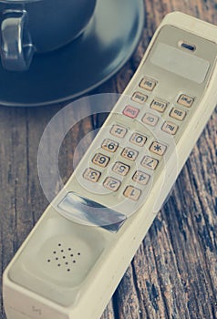 Vintage mobile phone with coffee cup