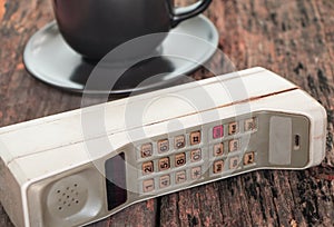 Vintage mobile phone with coffee cup