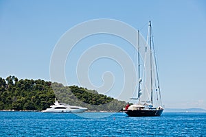 Vintage and modern yacht in front of Panormos beach at morning, Panormos bay, Skopelos island