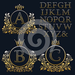 Vintage monogram kit. Golden patterned letters and floral coat of arms frames for creating initial logo in antique style