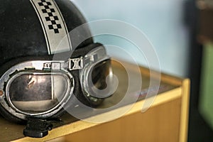 Vintage Motorcycle Helmet with Goggles on Wooden Table