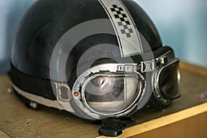 Vintage Motorcycle Helmet with Goggles on Wooden Table