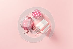 Vintage muffin tins and sugar pearls on pastel pink background photo