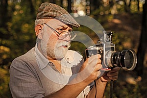 Vintage is my style. Old photographer look in vintage camera outdoors. Bearded pensioner take travel photos. Vintage