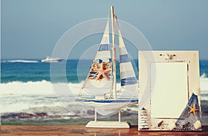 Vintage nautical frame with starfish on wooden table and sea beach background. retro filtered image