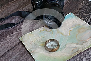 Vintage navigational compass with a camera on a hand made map