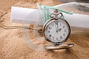 Vintage necklace watch on the sand beach