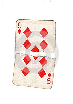 A vintage nine of diamonds playing card torn in half.