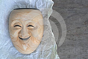 Vintage noh mask made of wood on paper on wood table