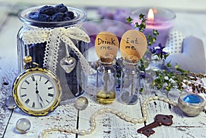 Vintage objects, tiny bottles with labels eat me and drink me, old clocks, key and honey berry in jar