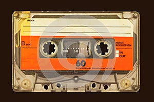 Retro styled image of an old audio compact cassette in front of a dark brown background