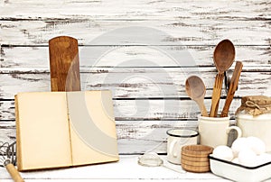 Vintage old baking kitchenware and recipe book on white wooden background