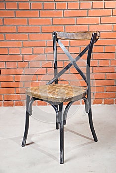 Vintage old black wooden chair in grungy interior. Loneliness, estrangement, alienation concept