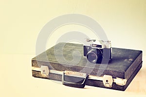 Vintage old briefcase and old camera. retro filtered design