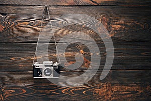 Vintage old camera hang on nail over wooden background
