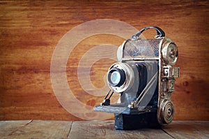 Vintage old decorative camera on brown wooden background. room for text.