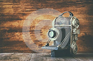 Vintage old decorative camera on brown wooden background. room for text.