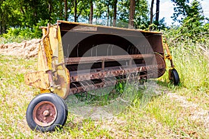 Vintage and old-fashioned yellow-painted hay tedder