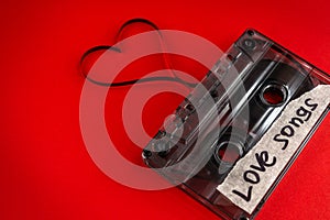 Vintage old film music cassette on a trendy pink red background with the inscription love song, background music, music lovers