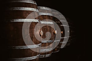 Vintage old oak barrels of wine, cognac in the wine dark vaults of the winery