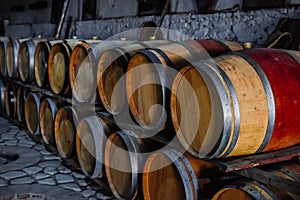 Vintage old oak barrels of wine, cognac in the wine dark vaults of the winery