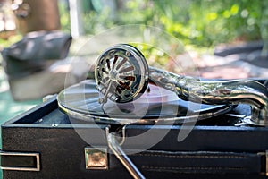 Vintage old record player gramophone needle on vinyl record. Round shiny metal needle holder head reproducing music