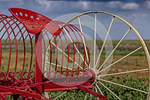 A vintage old red farm plow on a field at Sandstone Estates